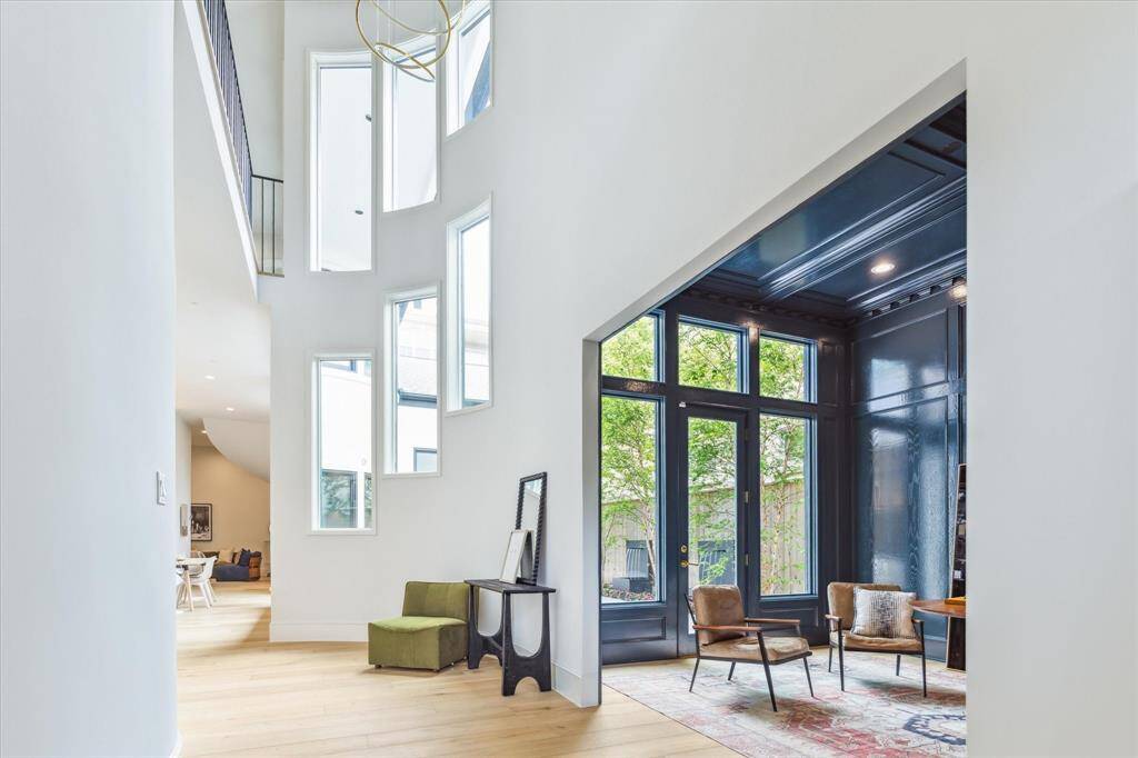 Soaring ceilings and curved architecture welcome you into a light-filled entry, where cascading windows and sculptural lighting set a tone of modern elegance.