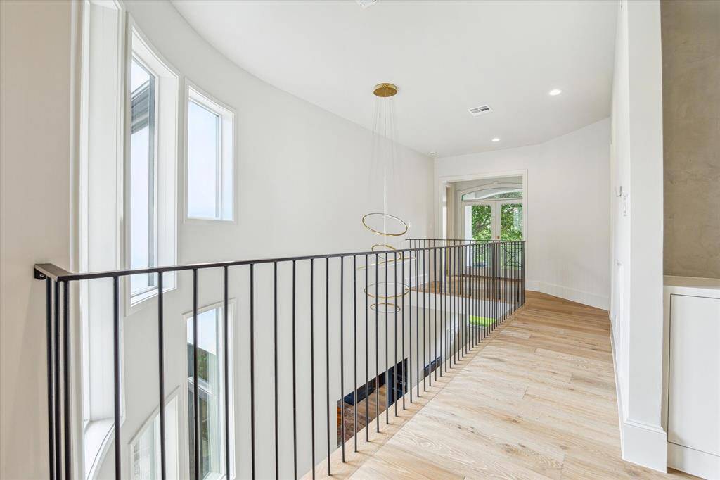 A bright and airy upstairs landing accented by sculptural lighting and panoramic windows.
