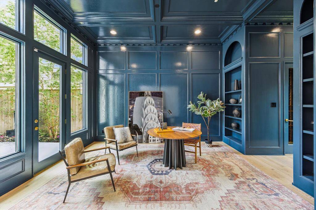 The richly paneled study makes a striking statement with its lacquered walls, custom millwork, and abundant natural light—perfect for work or reflection.