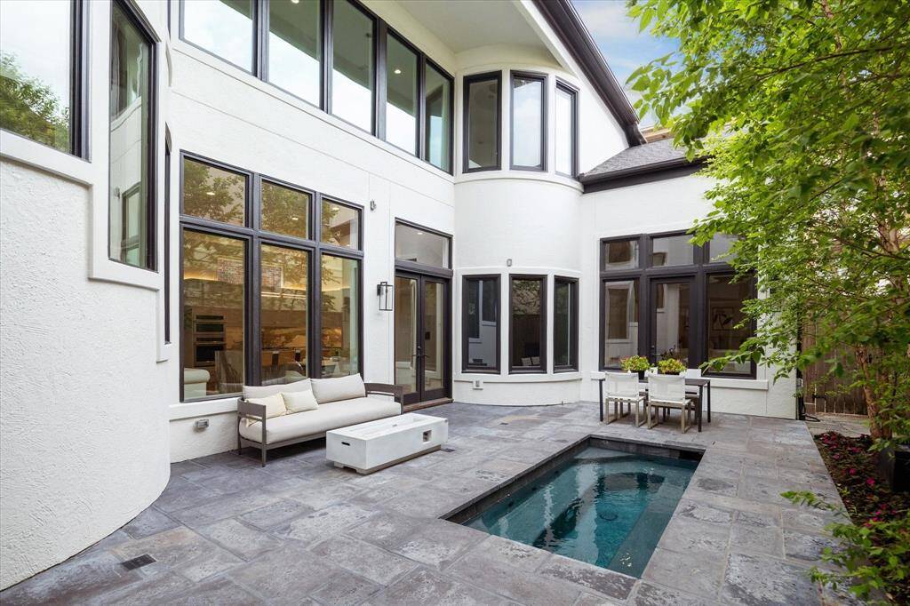 A stunning view of the home’s architectural detail, this outdoor space balances beauty and function with multiple lounge and dining zones surrounding the spa.