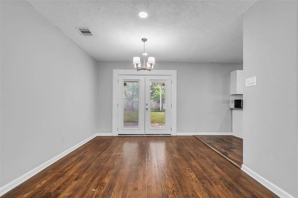 Another view of the dining area shows a simple chandelier overhead, adding light and character to the space. It’s a comfortable spot for everyday meals or casual gatherings.