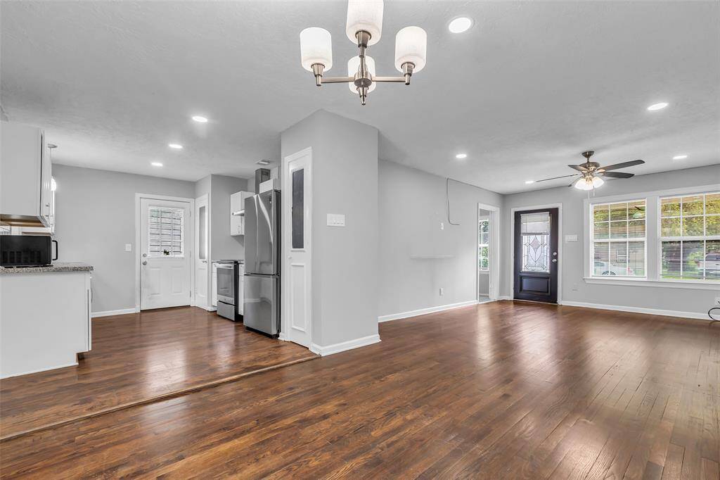 From this corner, you can see the kitchen, living area, the door to the primary bedroom, and the main entrance—highlighting the home's open and connected layout.