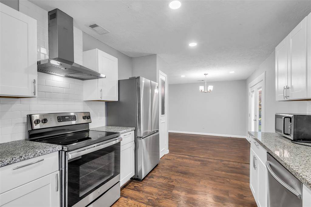 The kitchen features a durable granite countertop and sleek, minimalistic cabinetry, creating a clean and functional space for cooking and storage.