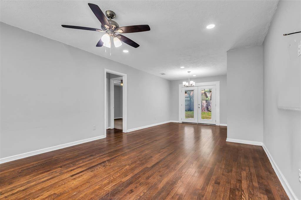 As you step inside, you’re welcomed by a central living room featuring durable hardwood flooring. Its location at the heart of the home makes it a natural gathering space for everyday moments and special occasions.