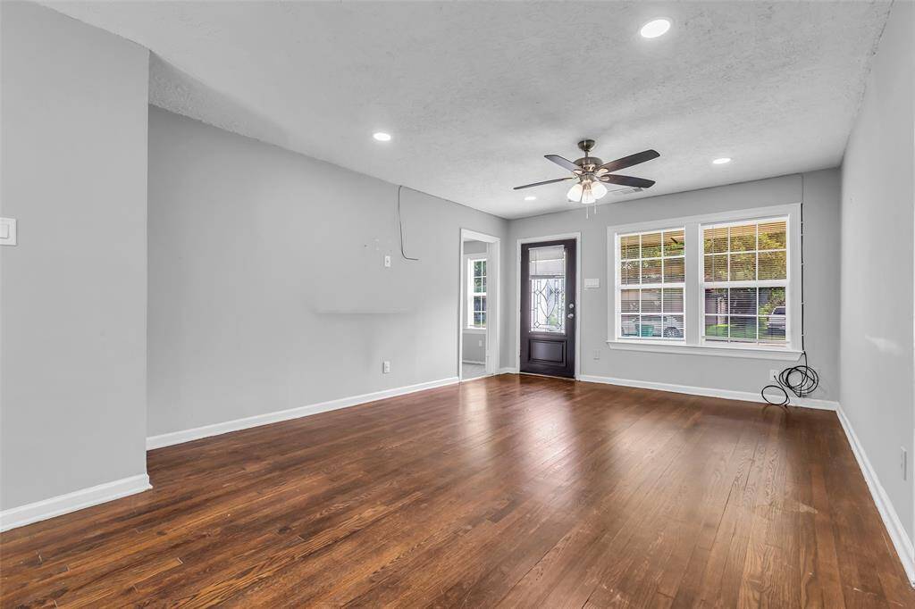 From this corner of the living room, you can see the main entrance and the doorway to the primary bedroom, located at the opposite end. The open layout adds to the home's easy flow and visibility.