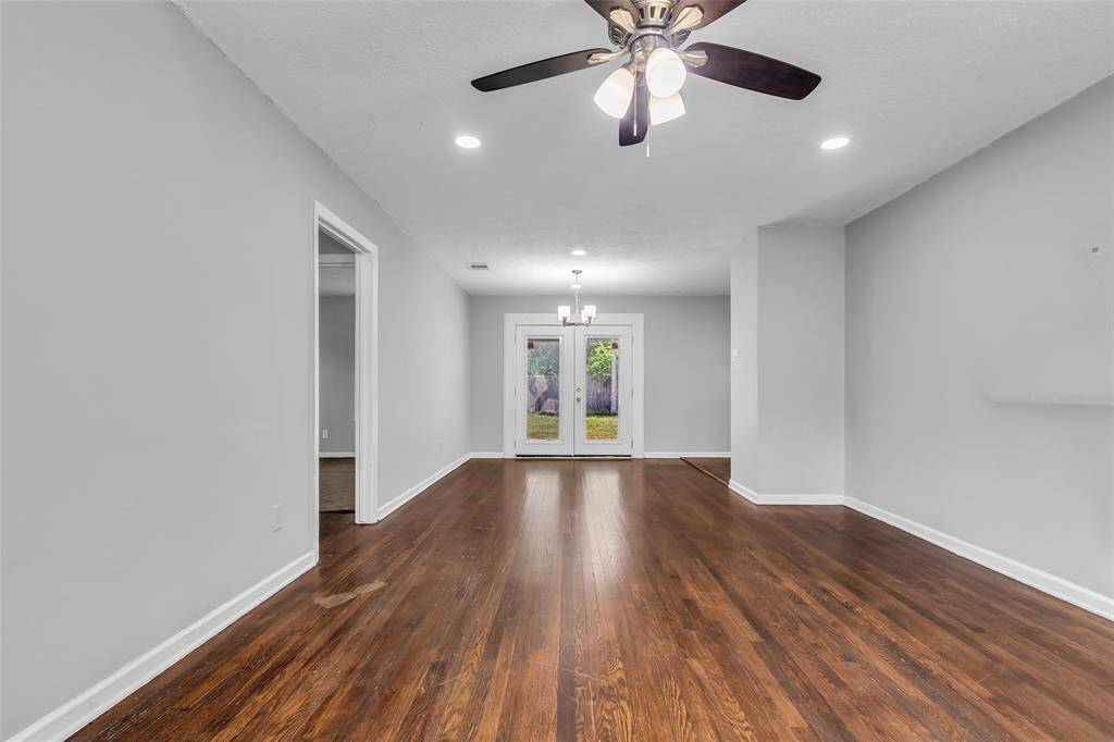 From the main entrance, you’ll see the open layout unfold—on the left, a hallway leads to the secondary bedrooms, while glass doors at the far end provide access to the backyard. To the right, an open doorway leads into the kitchen.