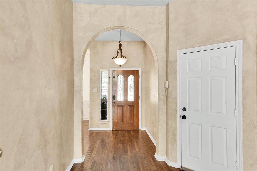 This room features a clean, neutral design with light beige walls . It includes a ceiling fan with lights and a window for natural light. The space is versatile, ideal for a bedroom or office.