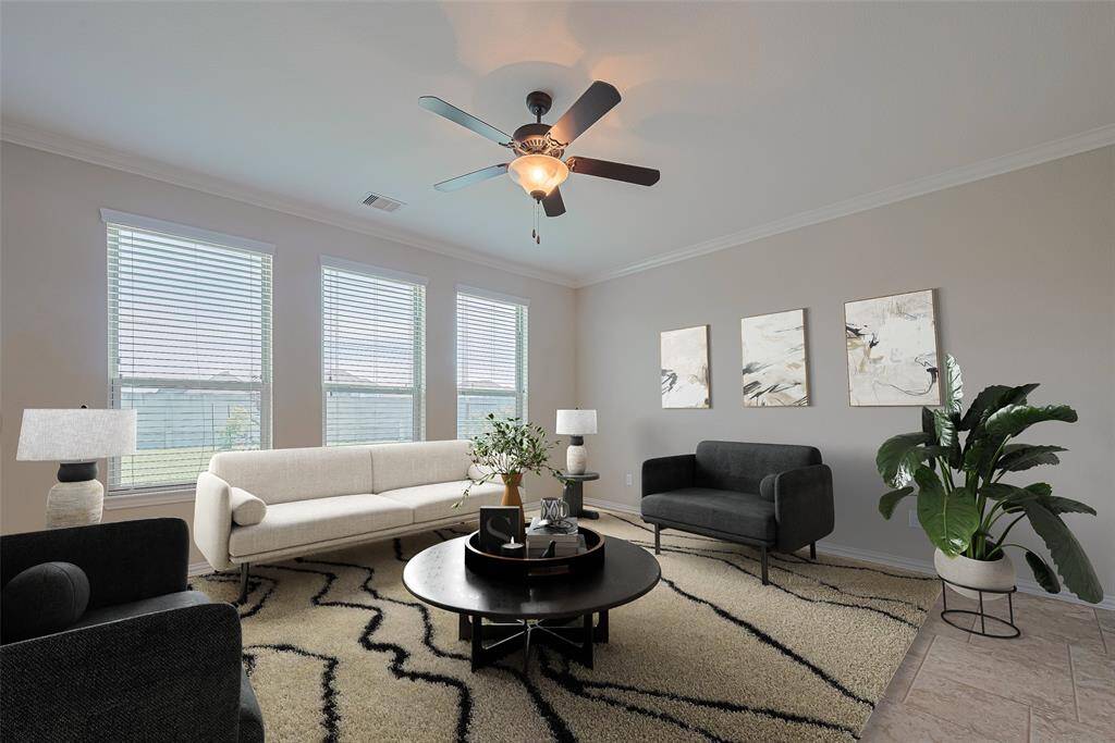 Styled with comfortable charm, this virtually staged living room highlights the oversized windows that flood the space with natural light and invite the outside in.