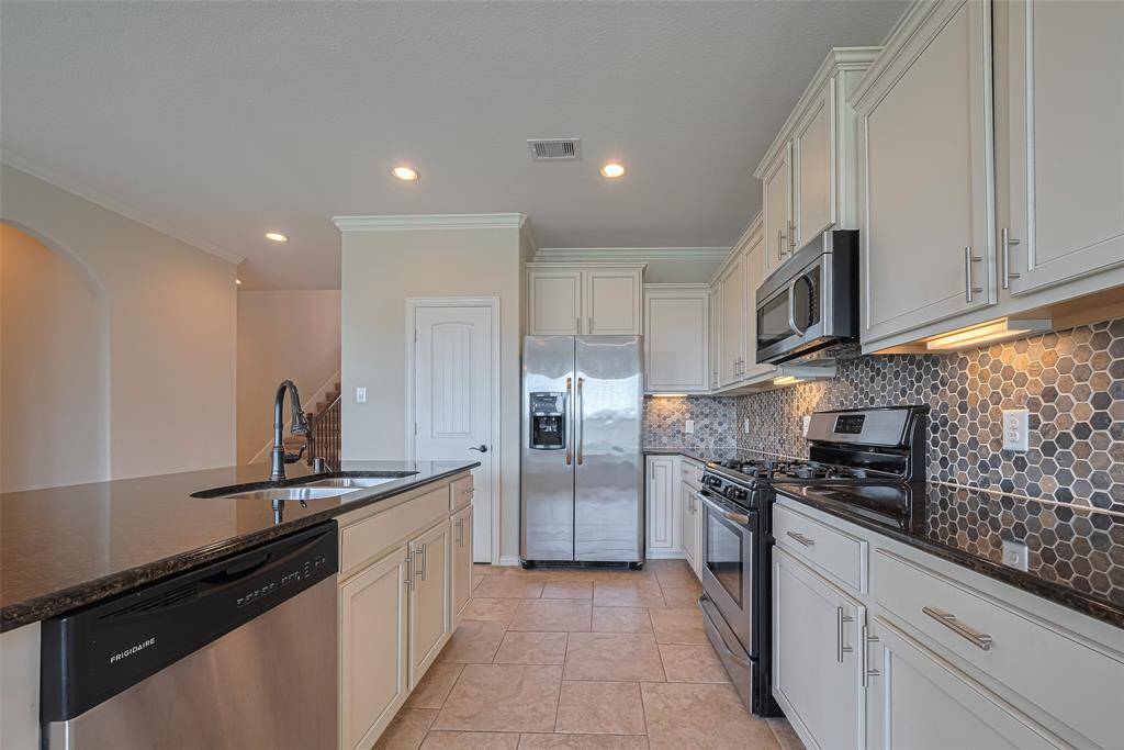 This efficient layout maximizes functionality, with cabinetry and appliances neatly lining one wall and a central island providing ample prep space.