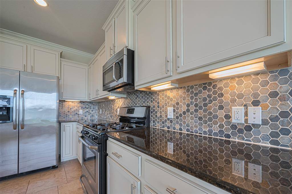 The pattern and layered hues of the backsplash catch the eye, enhanced by under-cabinet lighting that makes the colors pop.