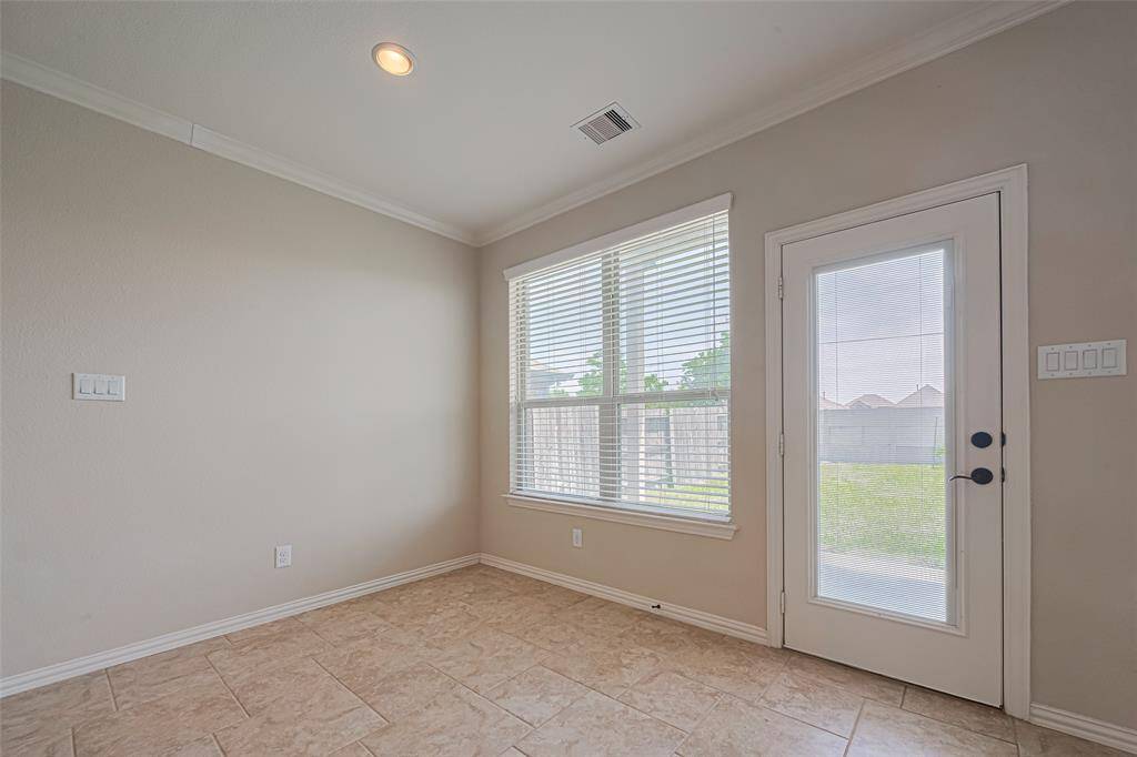 Nestled beside an oversized window and glass-paneled door, the breakfast nook bridges indoors and out with effortless charm.