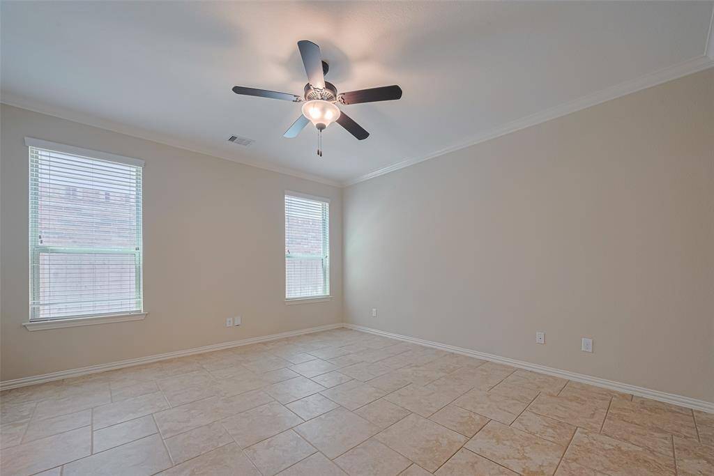 Expansive and serene, the primary bedroom features large windows that fill the space with light, and neutral tones that invite relaxation.