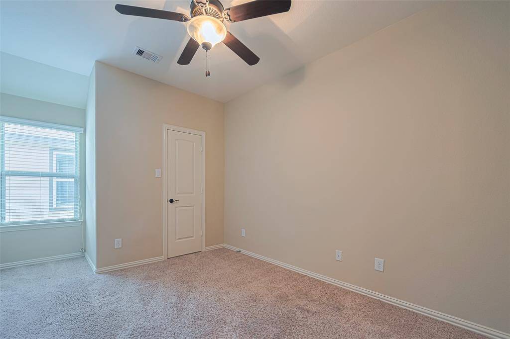 A well-sized second bedroom that enjoys soft natural light, carpeting, and a spacious closet.