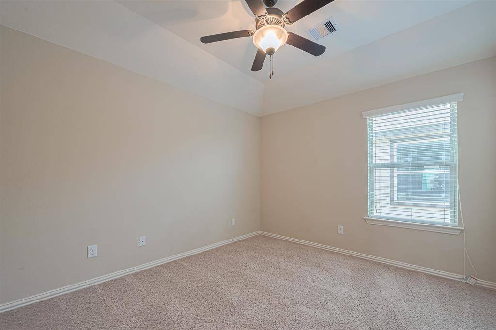 This third bedroom offers flexibility, with a recessed ceiling, fan, and a large window that lets in abundant daylight.