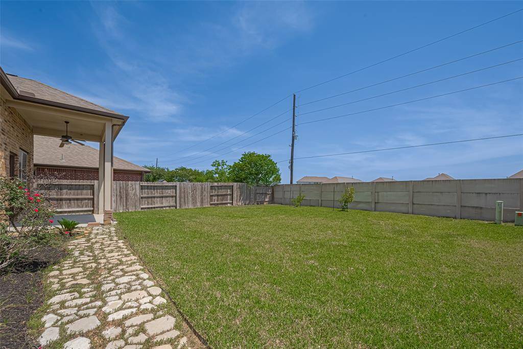 The expansive backyard stretches out behind the home, fully fenced for privacy and ready for anything—gardening, play, or pure relaxation.