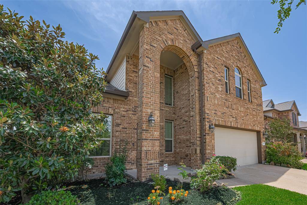 From beneath the towering front arch, the height and presence of the home is unmistakable—an impressive welcome for all who enter.
