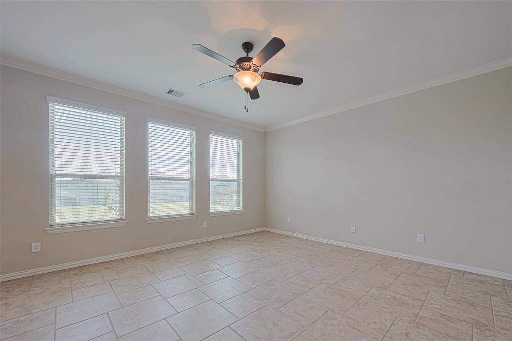 Spacious and sunlit, this living area features a ceiling fan for added comfort and an expansive row of windows that brightens every corner.