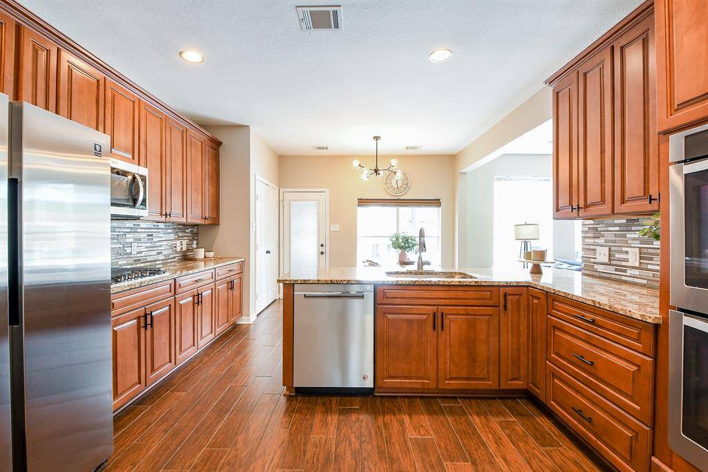 The Rich Cherry Wood Cabinets that pairs perfectly with the Matching Flooring, creating a Warm, Cohesive look.