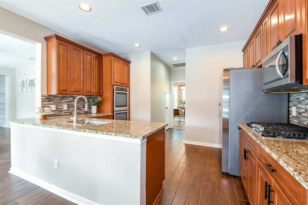 A sleek glass backsplash adds a touch of craftsmanship and modern elegance to the kitchen.