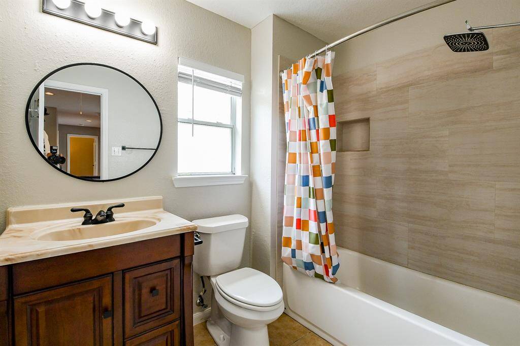 This inviting bedroom features a large window overlooking the front of the home, filling the space with natural light and offering charming views of the neighborhood.