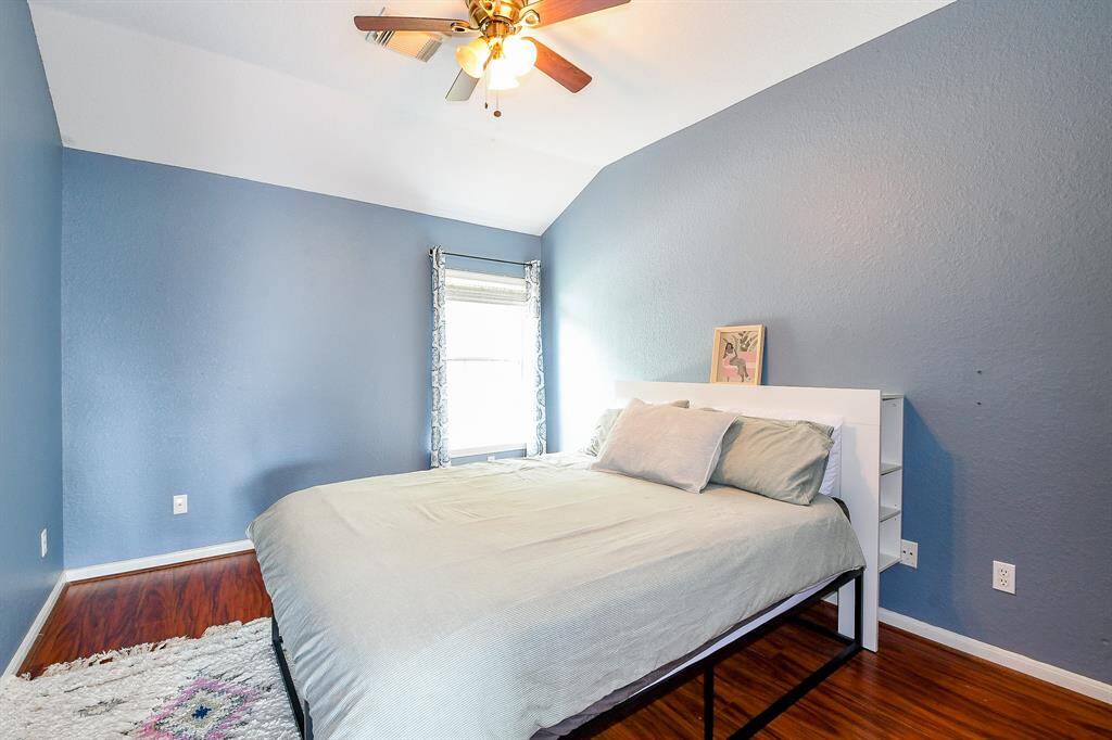 The primary bedroom is bathed in abundant natural light, thanks to large, thoughtfully placed windows that create a warm and welcoming atmosphere.