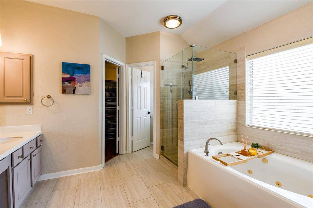 The Primary Bath showcases Two well-placed Windows that bring in Natural Light while maintaining privacy, along with privacy doors into the Walk-In Closet, and toilet area.