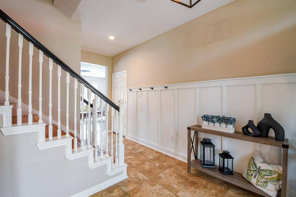 The Entryway features Classic Block Paneling that adds Architectural Charm and enhances the Spindled Staircase.