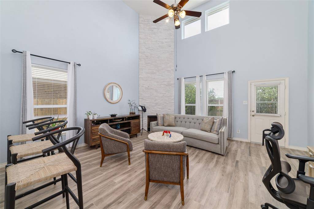 Living room feature high ceiling and plenty of windows to catch natural light.