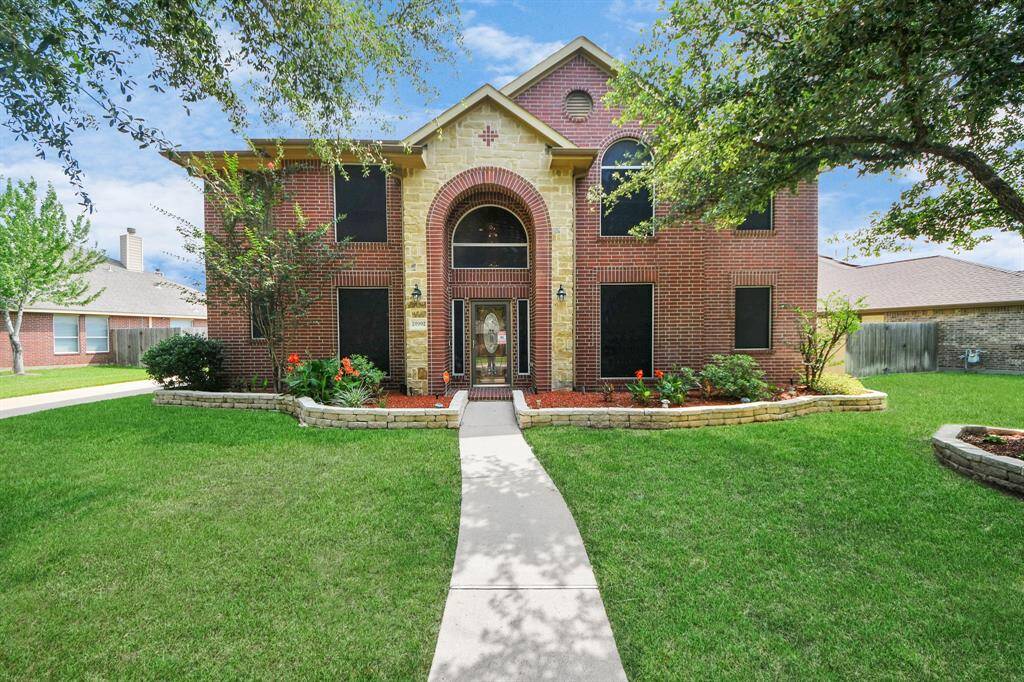 This stunning home boasts a striking stone and brick exterior, complemented by a well-maintained landscape that enhances its curb appeal.