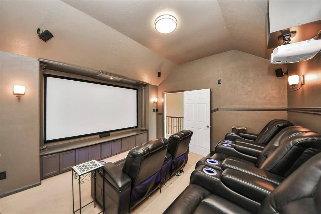 Designed for immersive entertainment, this media room boasts plush carpeting that enhances comfort and acoustics. Rows of elegant sconce lighting create a warm, cinematic ambiance, setting the perfect stage for movie nights and gatherings.