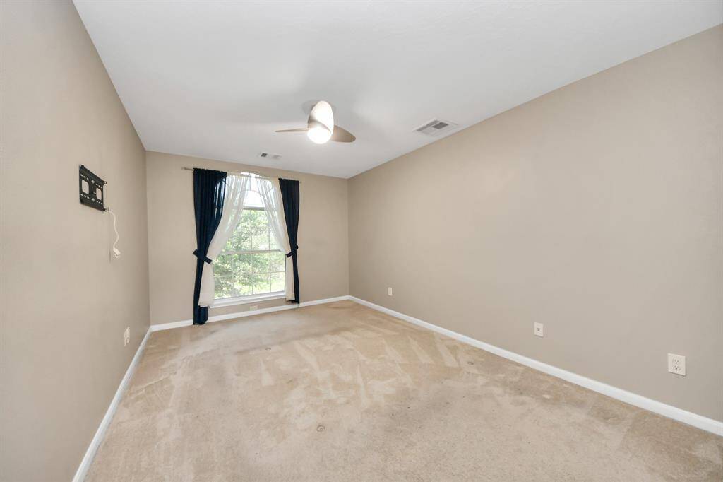 This bright and spacious bedroom offers versatility, providing ample room for a cozy seating area or a functional home office setup. Its well-lit ambiance enhances comfort, making it an ideal retreat for relaxation or productivity.