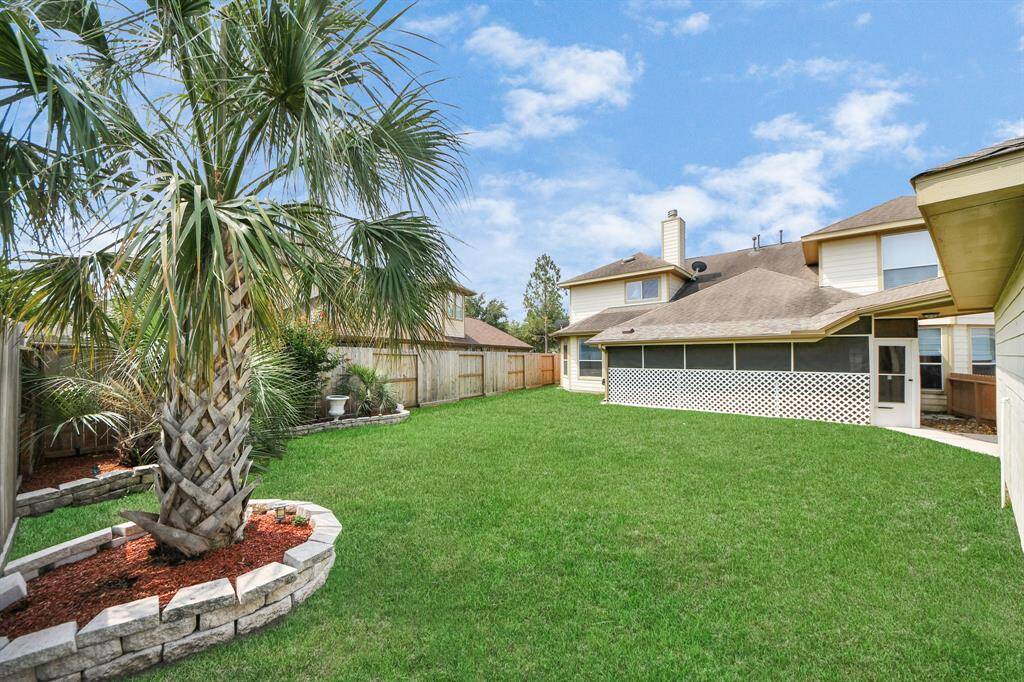 The patio is a shaded retreat overlooking the well-maintained backyard, providing plenty of space for outdoor relaxation.