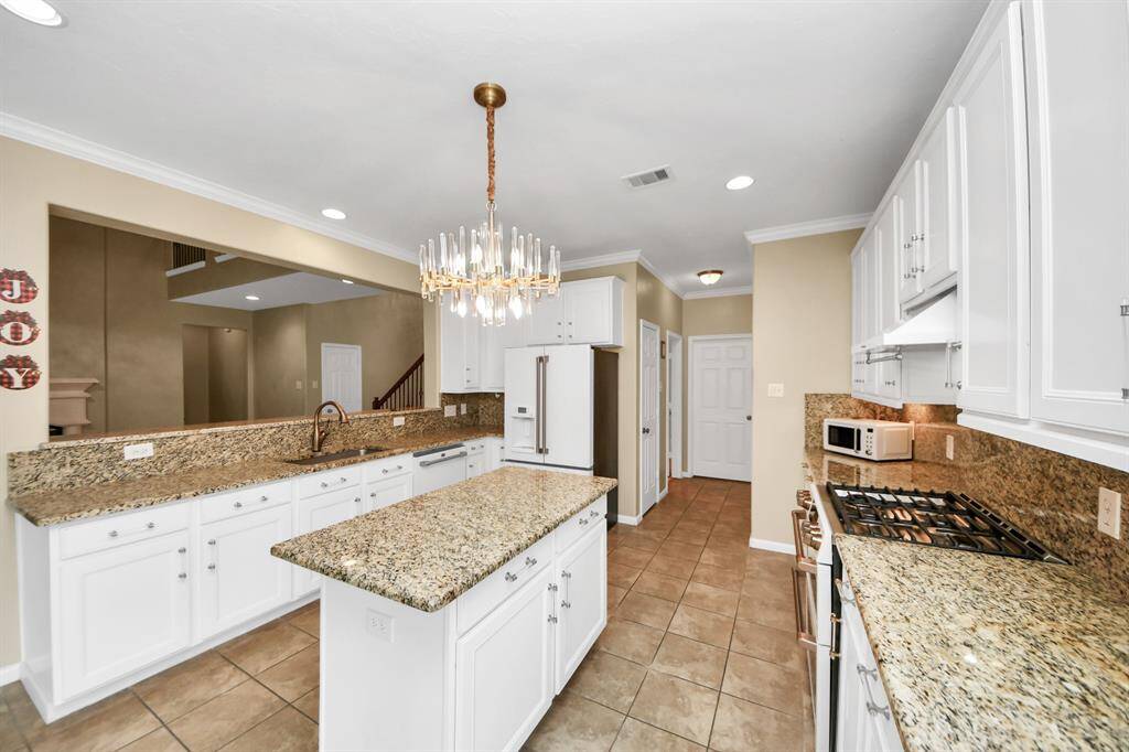 The heart of the home is this elegant site, with granite countertops, touchless faucet, top-notch CAFE appliances, a modern chandelier, and white cabinets, this is so elegant!!