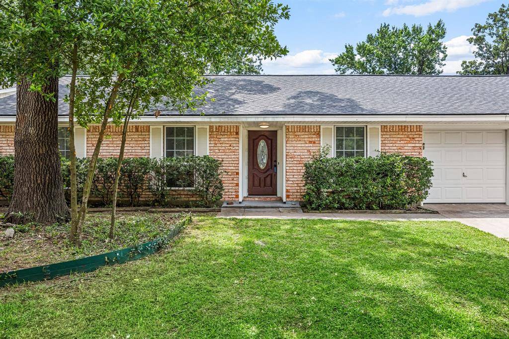 Charming single-story brick home with a welcoming front porch, surrounded by well-maintained landscaping and lush greenery. Features a spacious driveway leading to an attached garage, perfect for easy access and convenience.
