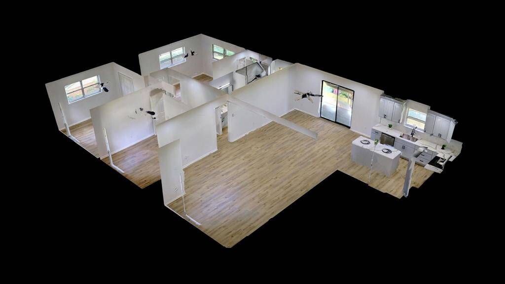 This is a 3D layout of a modern home featuring an open floor plan with hardwood flooring. It includes multiple rooms, a spacious kitchen with white cabinetry, and large windows for natural light.