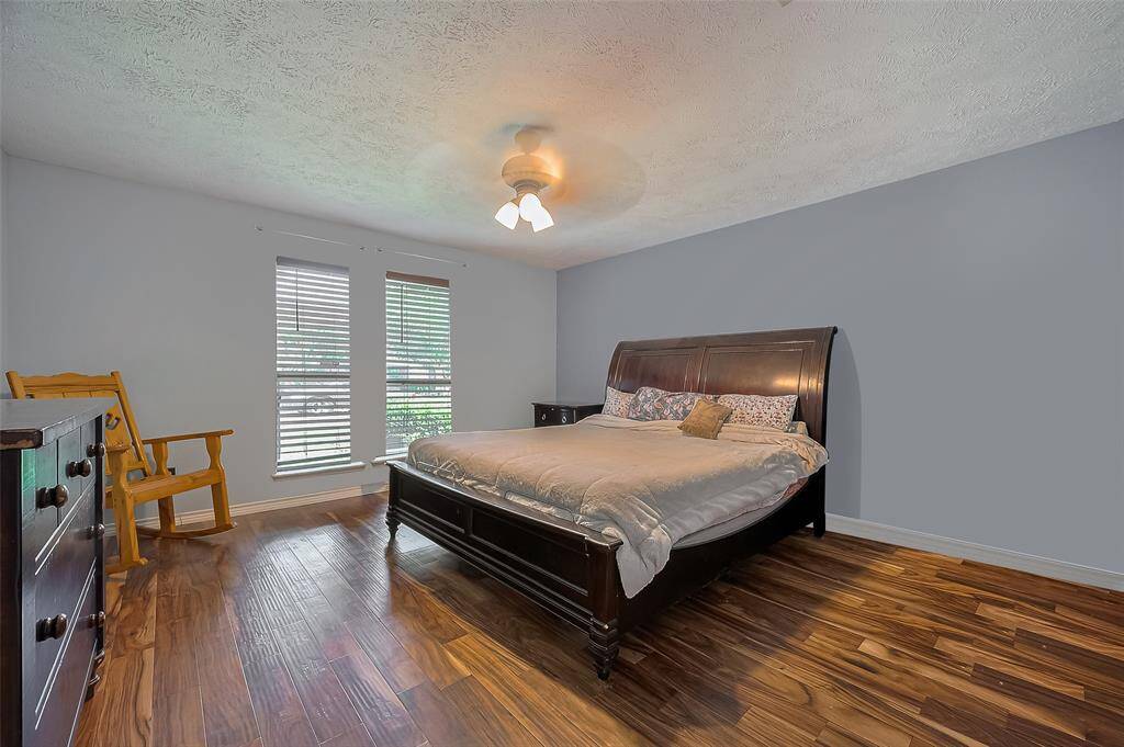 Spacious and serene, this primary retreat features rich flooring, soft natural light, and ample room for king-size comfort.