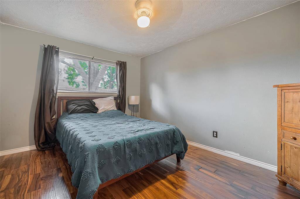 Cozy and serene, this secondary bedroom features wood-look flooring, soft natural light, and a peaceful ambiance for restful nights.