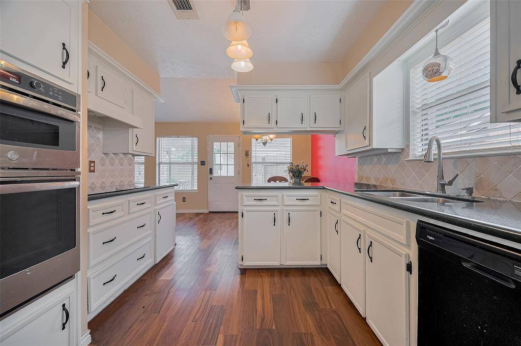 Thoughtfully designed kitchen features abundant counter space, updated lighting, and easy flow into the dining and living areas for effortless entertaining.