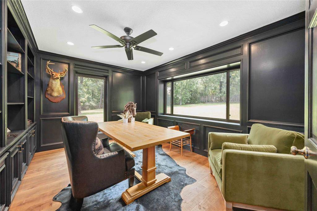 On the first floor, you'll find this amazing study with built-in shelving and cabinets. Large framed windows offer a stunning outdoor view.