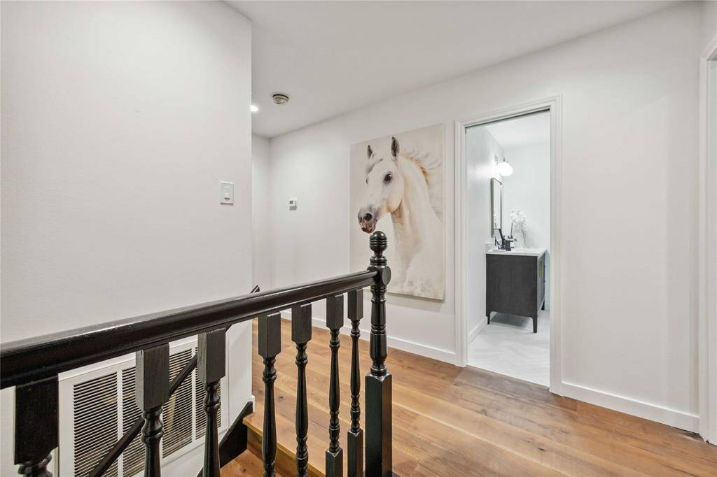 The black banister offers a dramatic contrast to the freshly painted walls upstairs.