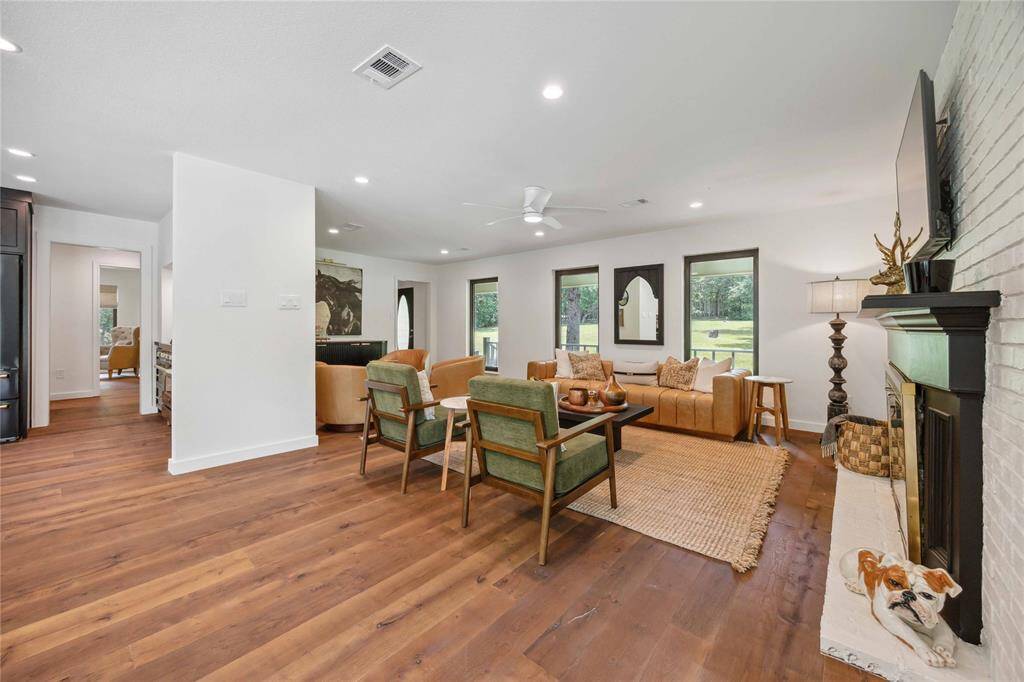 Step inside a luxurious living room with hand-cut and hand-scraped floors by Hardwood Design Company in College Station. High ceilings with recessed lighting draw your eyes to the large picture windows with a beautiful outdoor view.