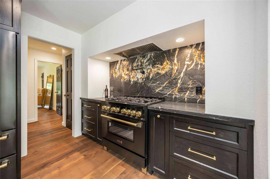 Z-Line Autograph Edition appliances, black leather granite countertops, and a stylish backsplash join together to create a chef's dream kitchen.