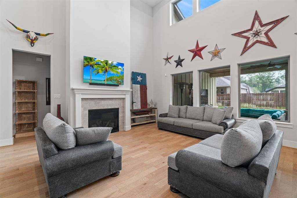 Soaring ceilings and wall-to-wall windows fill this open-concept living area with natural light.