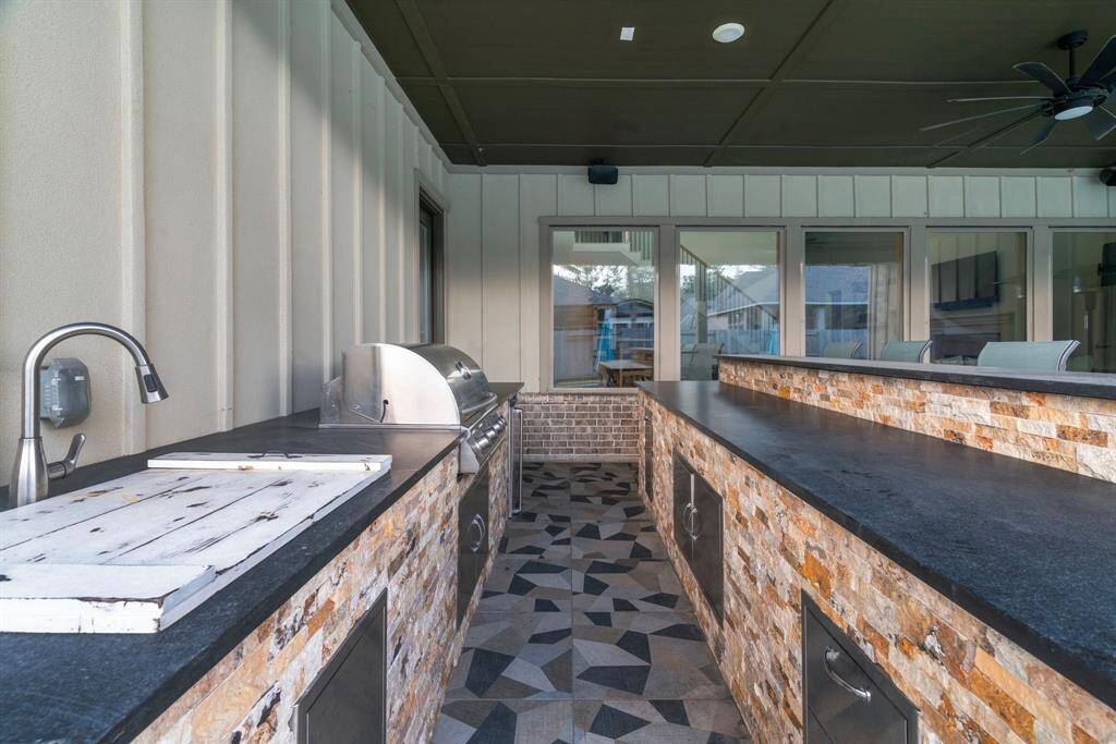 Built-in BBQ brilliance. This custom outdoor kitchen features stonework, prep sink, and high-end grill to impress guests year-round.