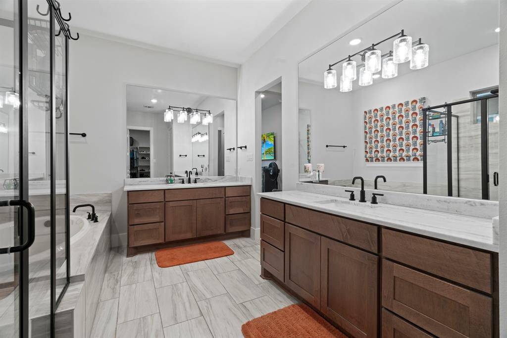The en suite bath offers a luxurious soaking tub, walk-in shower, dual vanities, and generous closet space—all designed for comfort and style.