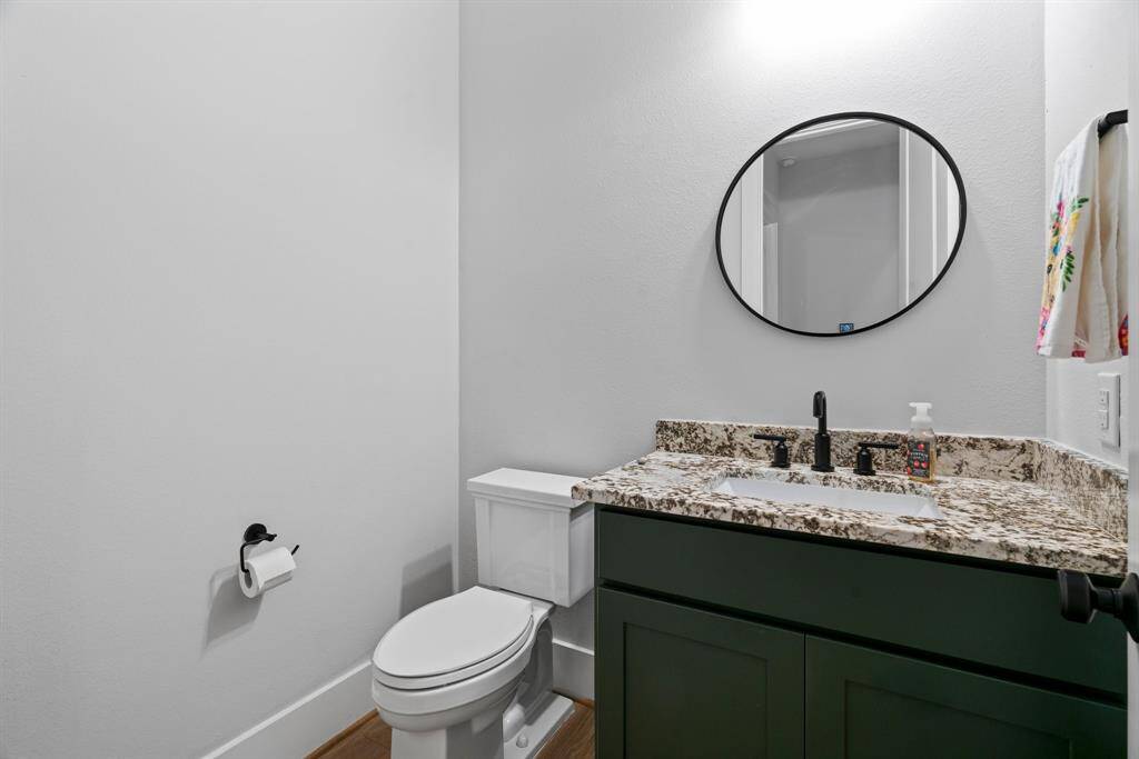 Stylish half bath with granite counters and bold, modern finishes—perfect for guests.