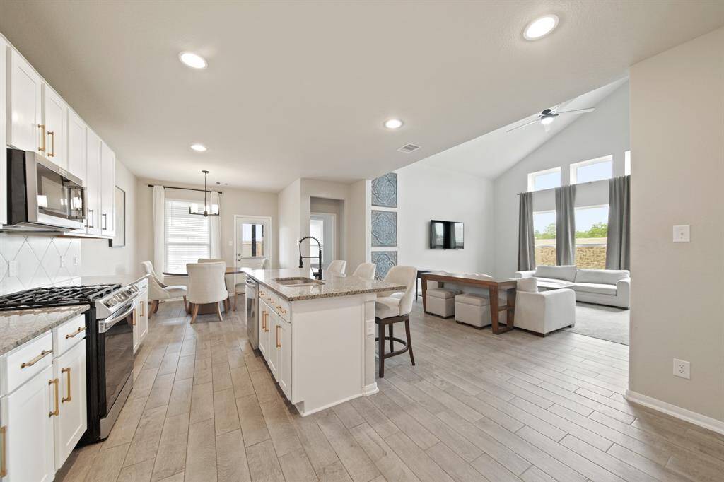 Fully equipped kitchen with recessed lighting, tile floors, tons of counterspace, and an island with breakfast bar.