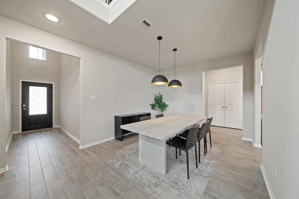 Smooth access from the foyer into the dining room. This stunning dining room has tile floors, and pendant lighting.
