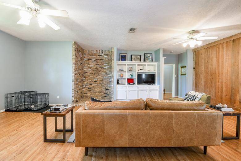 As you enter the home, you are welcomed by the spacious living area with built ins and a reclaimed timber feature wall.