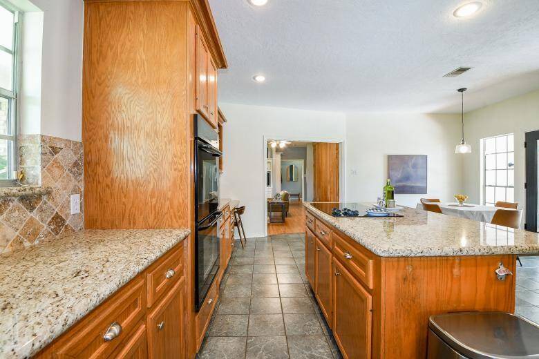 The kitchen has oak cabinets with granite counters and a tile backsplash.
